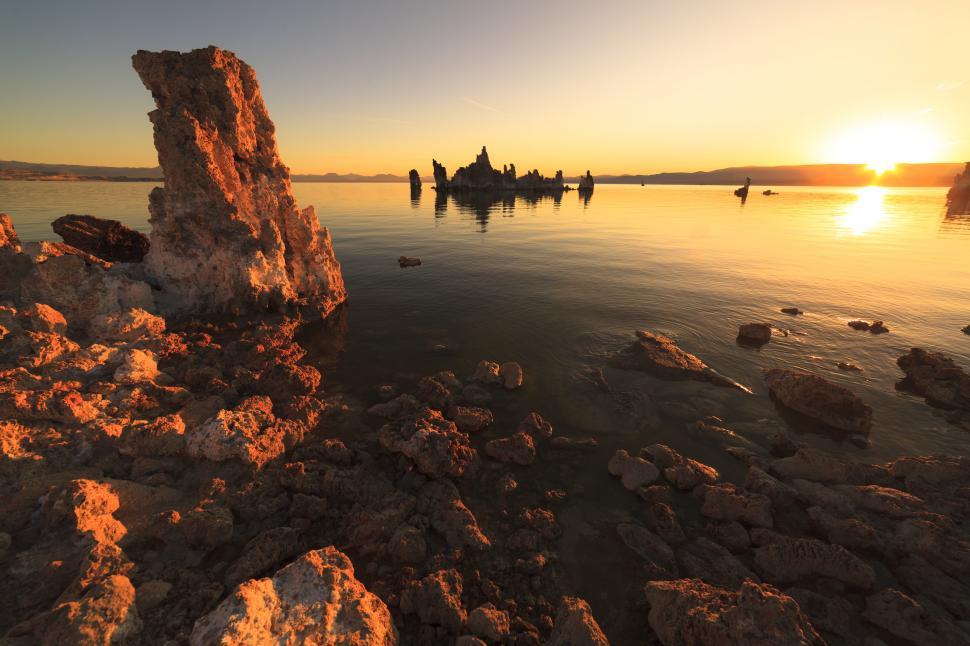 Free Image of A rocky shore with a sunset in the background 