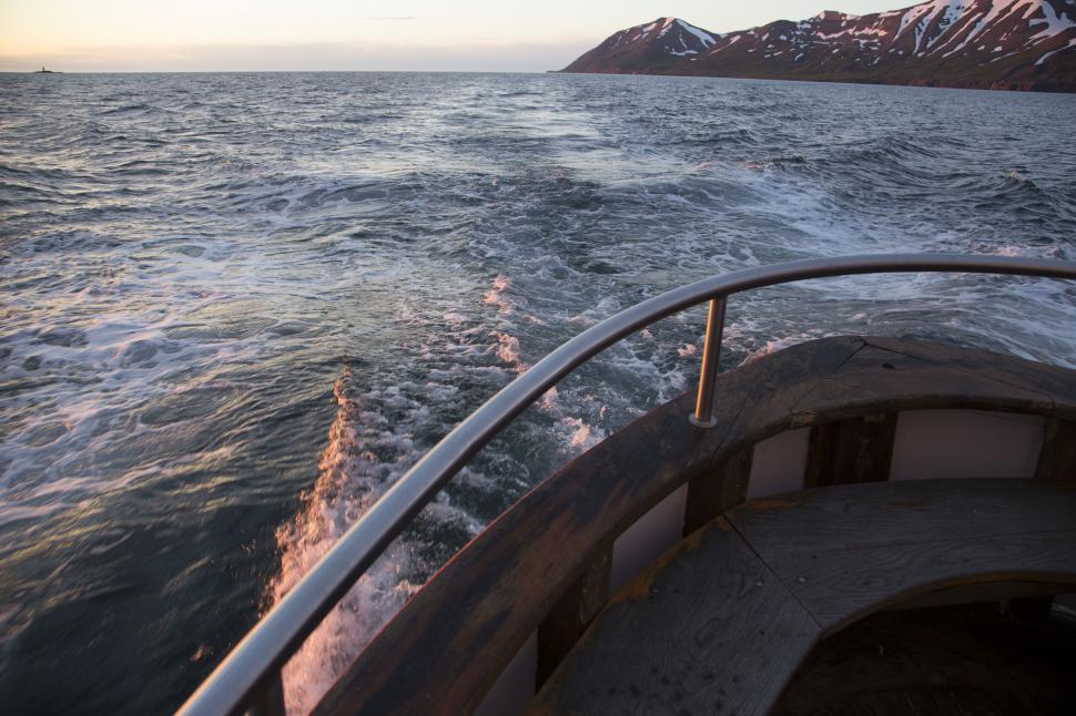 Free Image of A boat with a railing and mountains in the background 