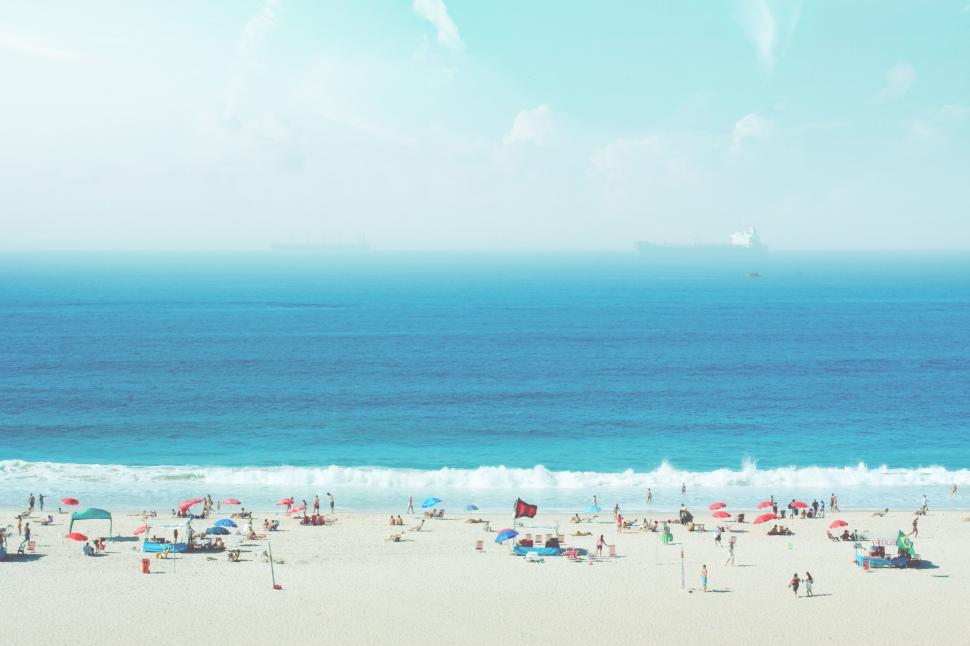 Free Image of A beach with people and umbrellas 