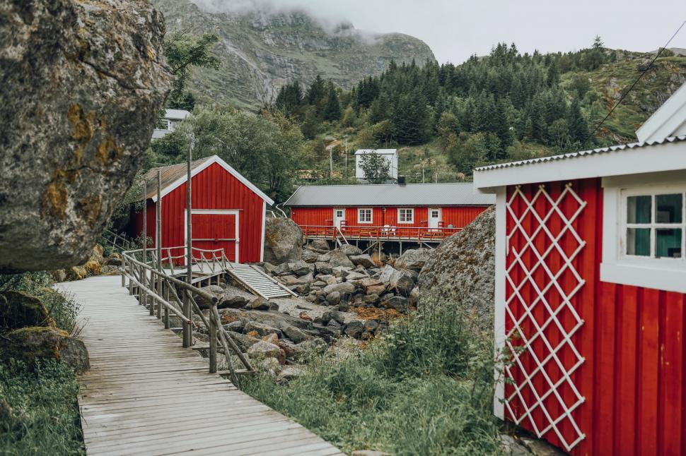Free Image of A wooden walkway leading to a red building 