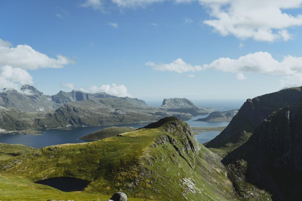 Free Image of A green hills with water in the background 