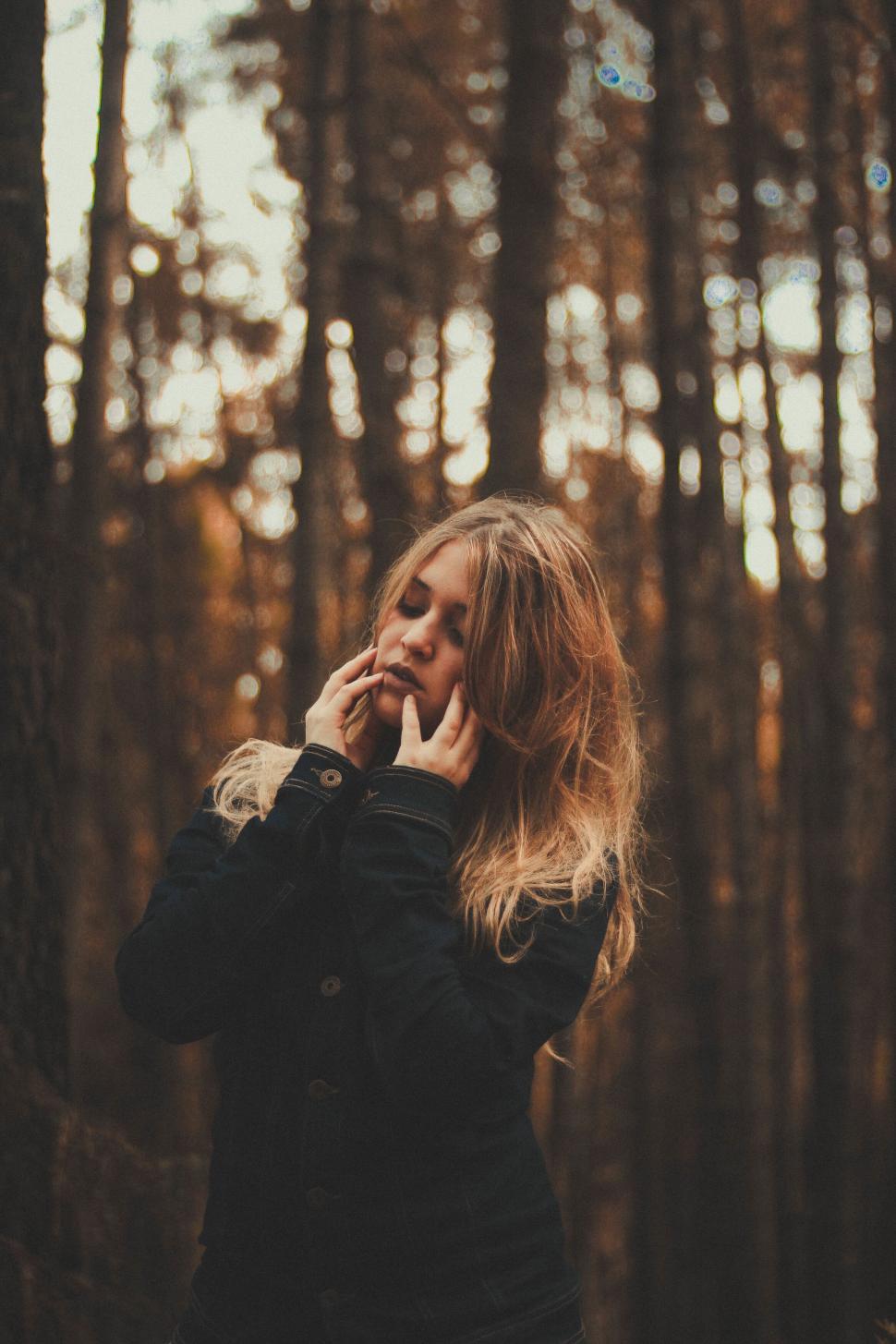 Free Image of A woman with her eyes closed in a forest 