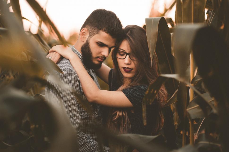 Free Image of A man and woman hugging in a field of plants 