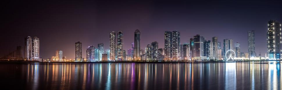 Free Image of A city skyline with lights reflecting on water 