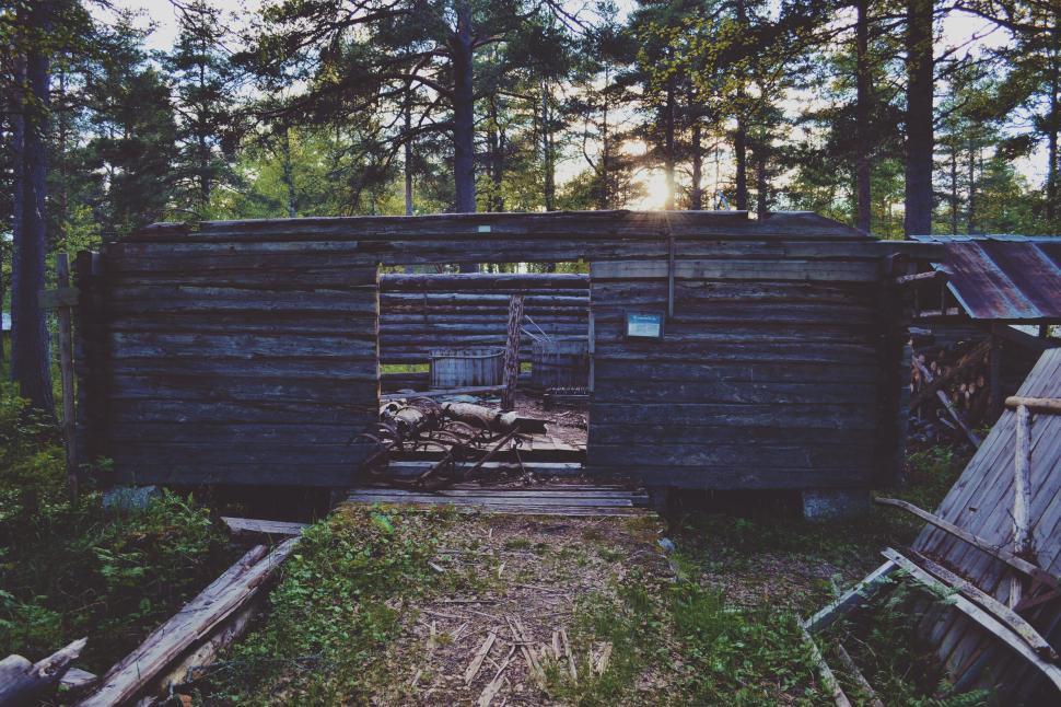 Free Image of A wooden building with a door open in the woods 