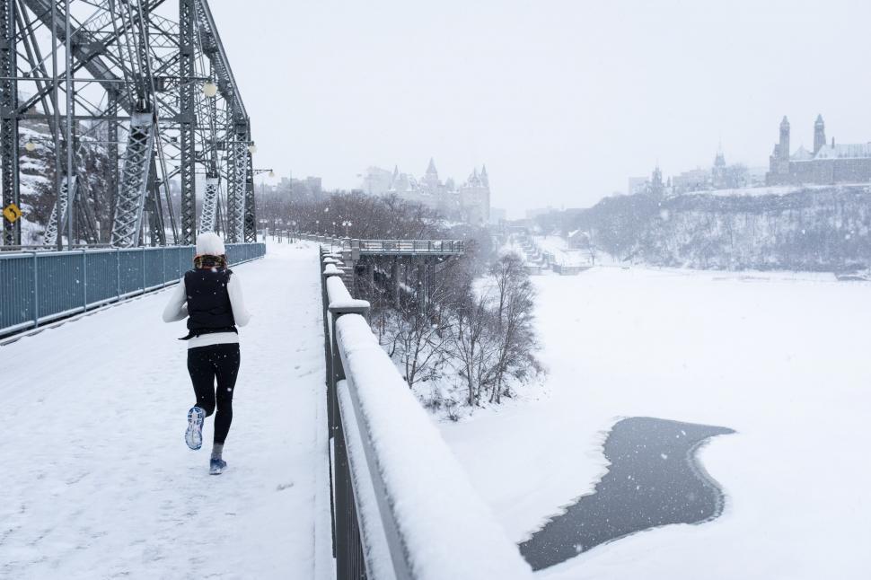 Woman jogging on bridge in city stock photo