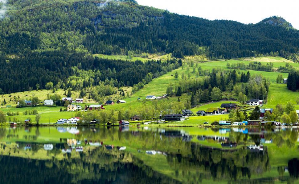 Free Image of A body of water with houses and trees in the background 