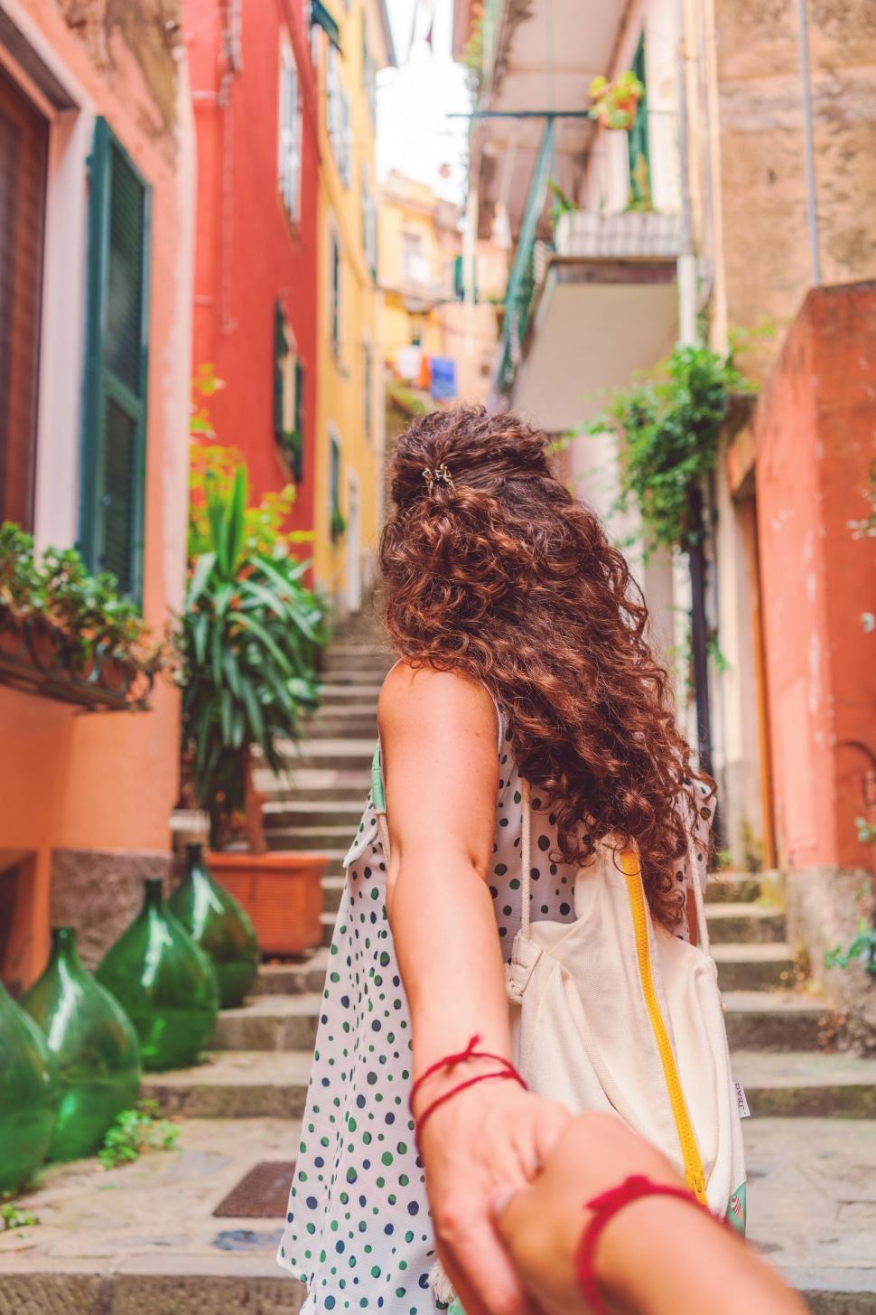 Free Image of A woman holding a hand of a man walking down stairs 
