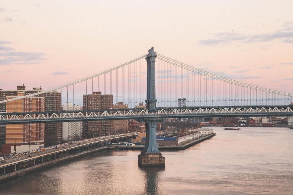 Free Image of A bridge over water with buildings in the background 