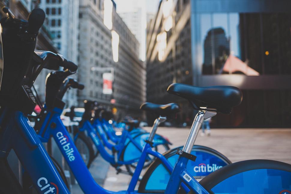 Free Image of A group of blue bicycles parked on a sidewalk 