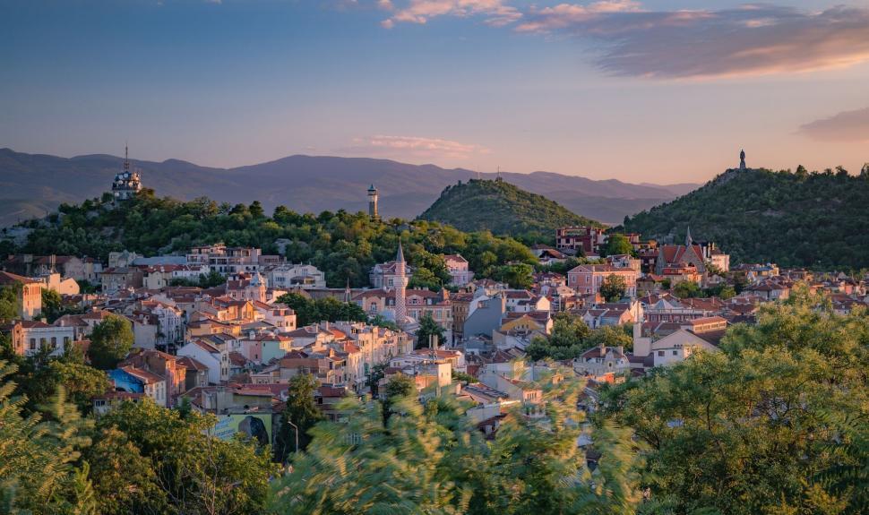 Free Image of A city with trees and mountains in the background 