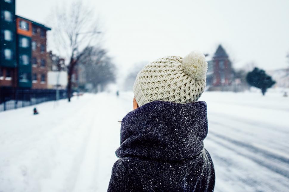 Free Image of A person in a hat and coat walking in the snow 