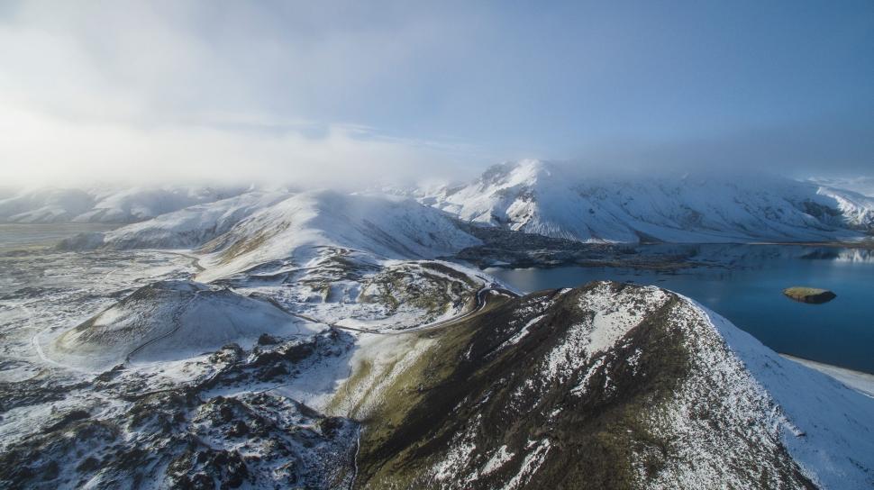 Free Image of A snowy mountain range with a body of water 