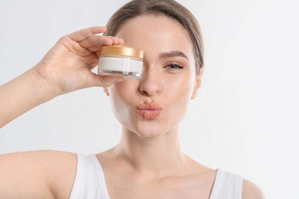 Free Image of A woman holding a jar of cream 
