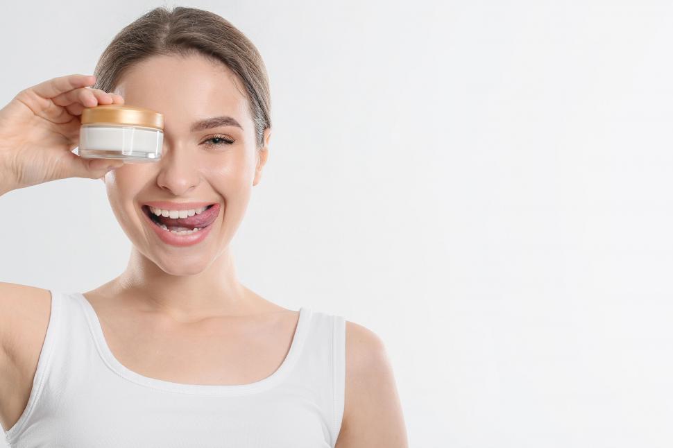 Free Image of A woman holding a jar of cream 
