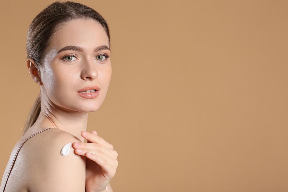 Free Image of A woman applying cream on her shoulder 