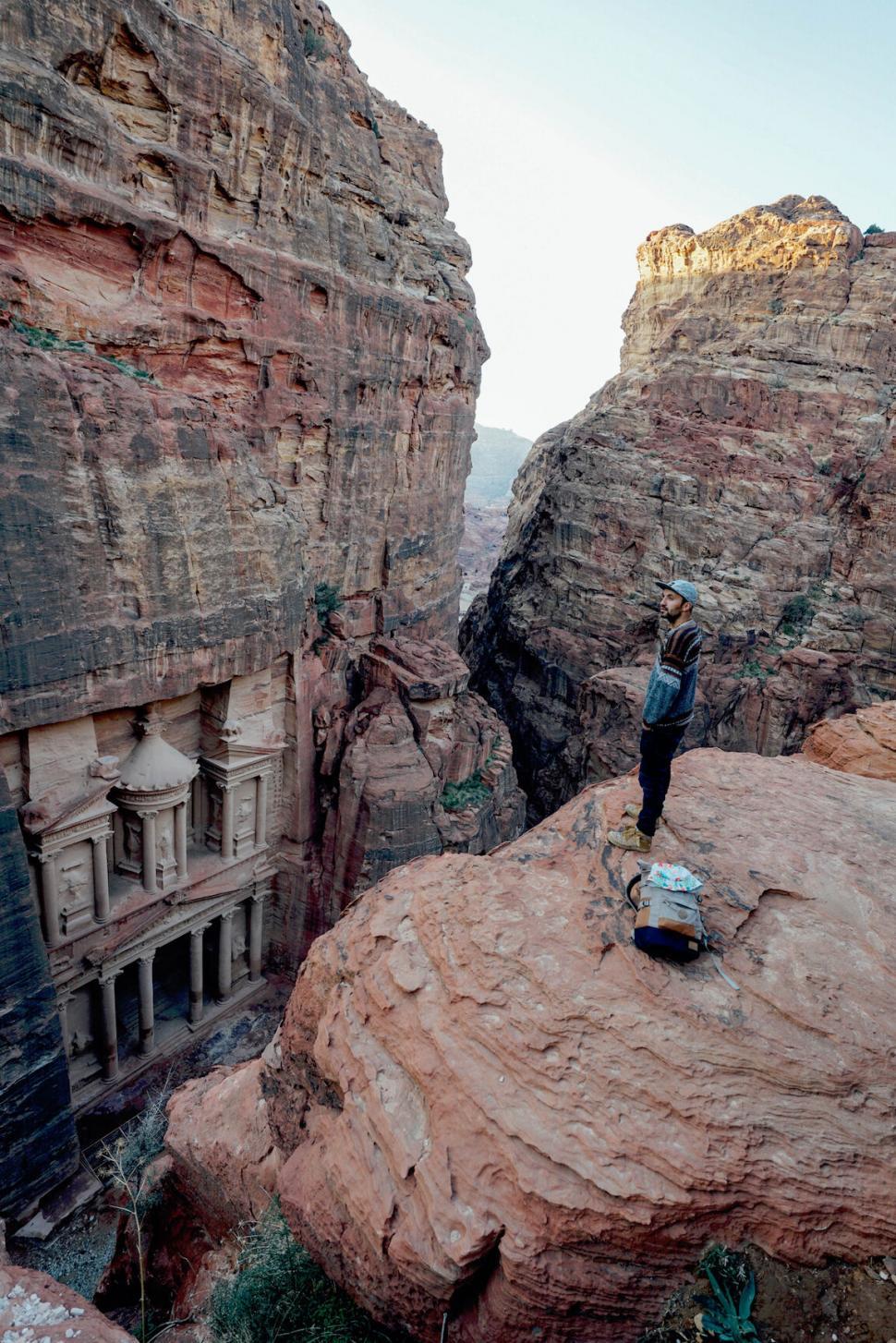 Free Image of Man Standing on Top of a Large Rock 