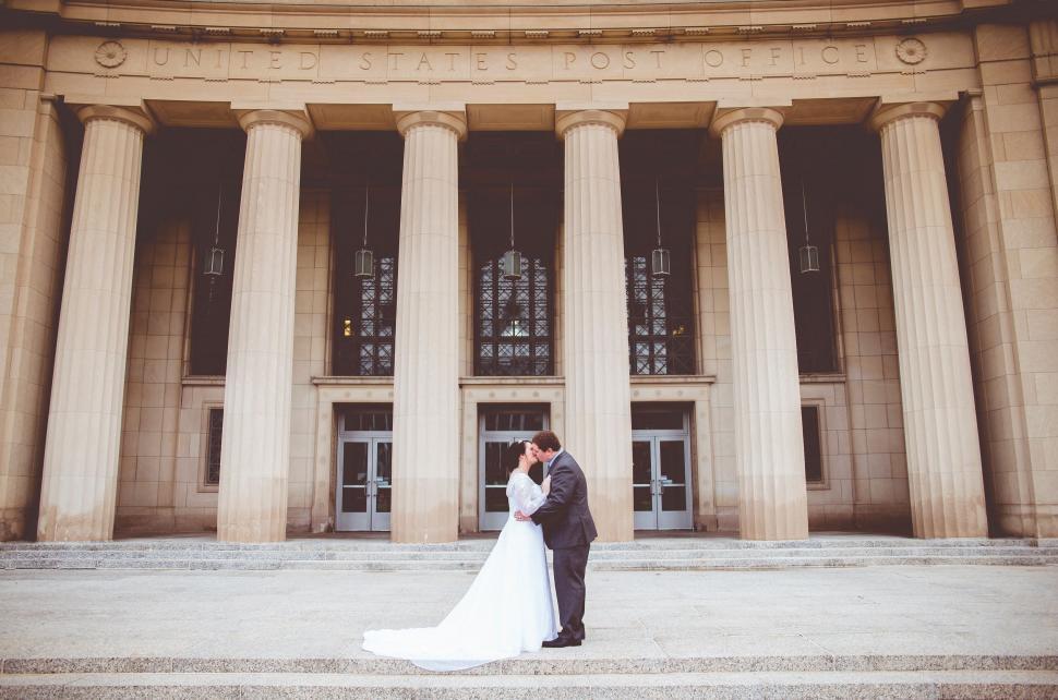 Free Image of Couple kissing in front of Post Office 