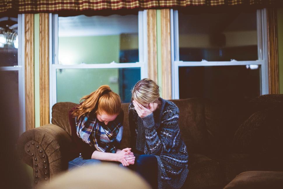 Free Image of Two people comforting each other on the couch 