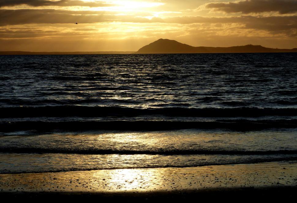 Free Image of Sunset silhouette over tranquil sea waters 