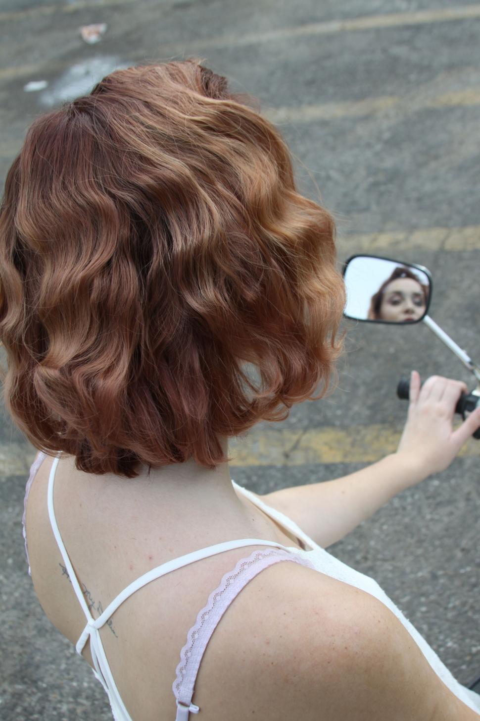 Free Image of Woman looking in the motorcycle mirror 