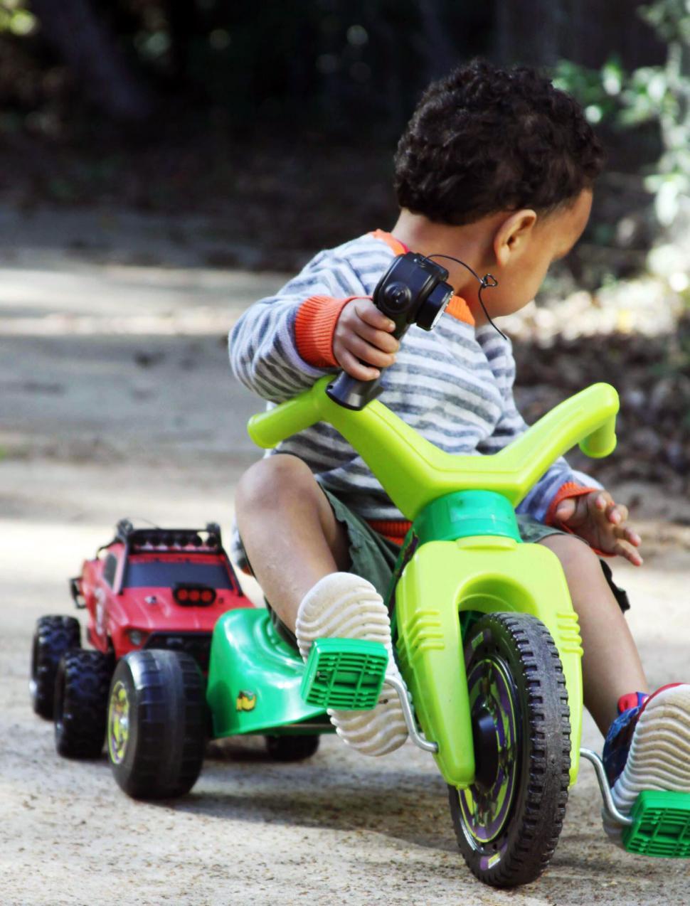 Free Image of Child on toy motorcycle tow truck 
