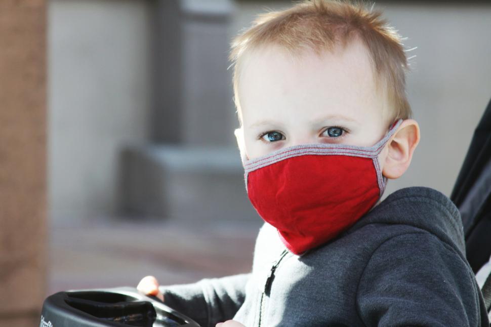 Free Image of Child in a black stroller with blurred face 