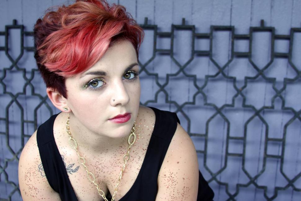 Free Image of Woman with red hair against blue backdrop 