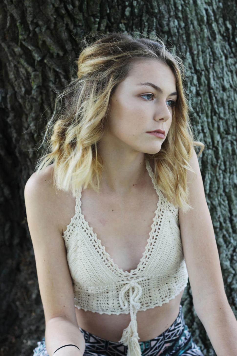 Free Image of Young woman in a knitted top outdoors 
