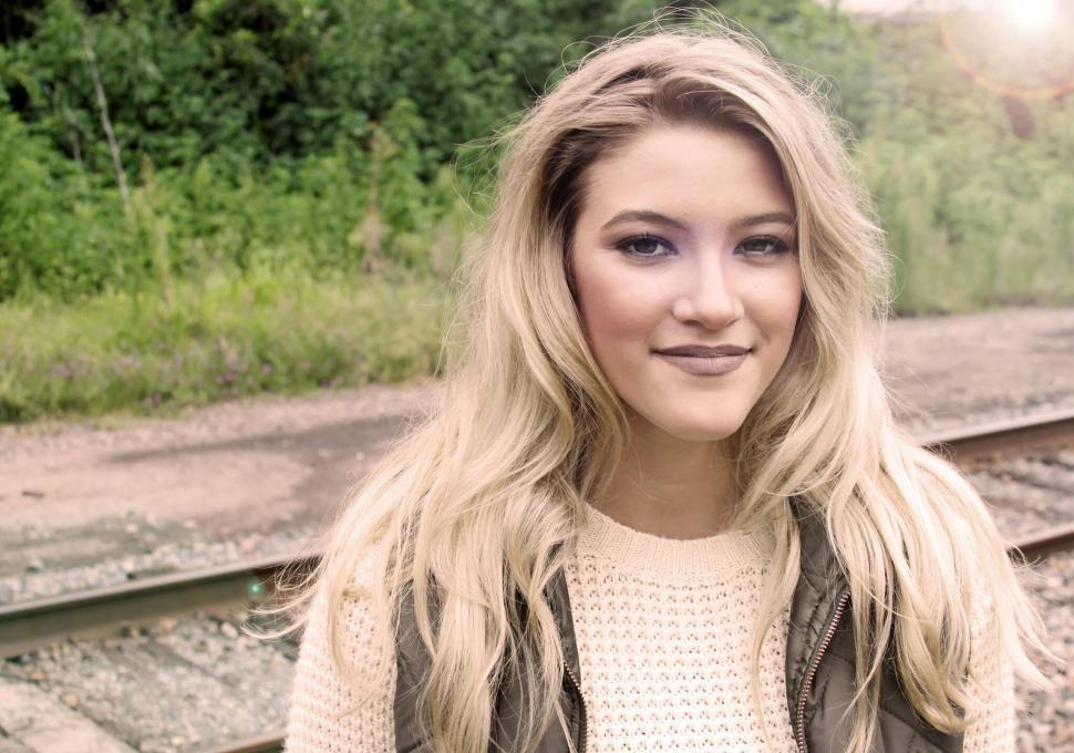 Free Image of Young woman posing by railroad in sunlight 