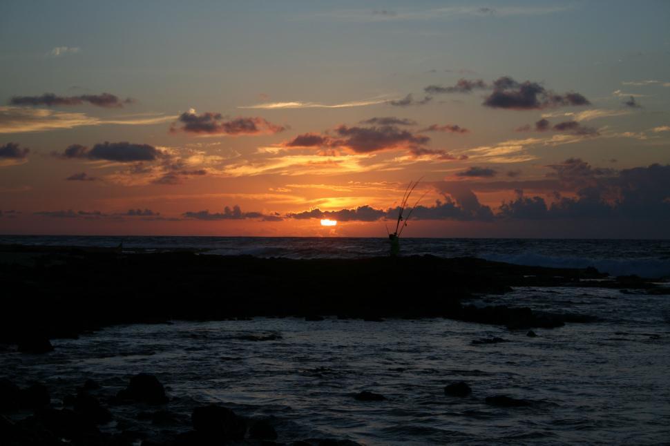 Free Image of Sunset scene with a silhouette of a fisherman 