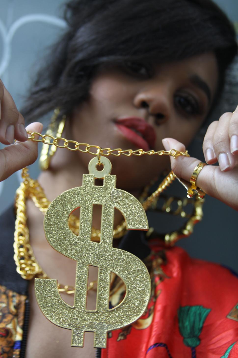Free Image of Person holding a large golden dollar sign 