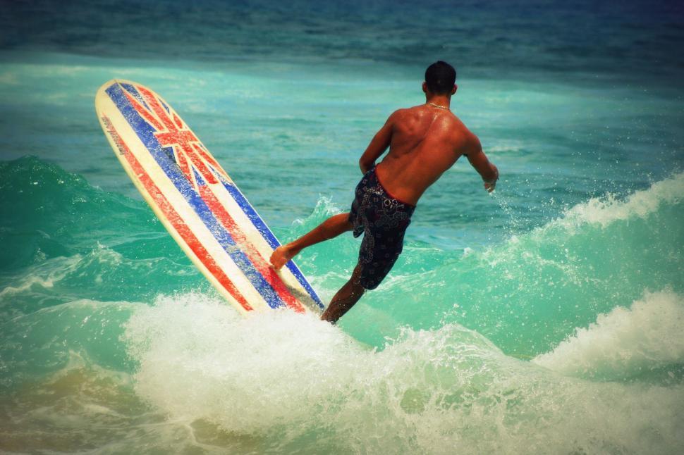 Free Image of Man running into the sea with a surfboard 