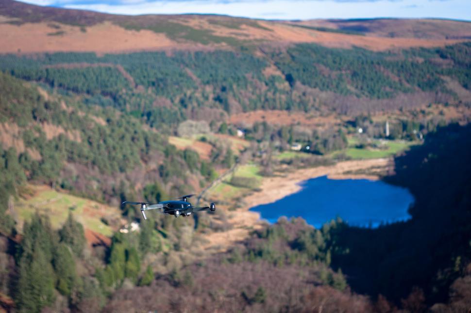 Free Image of Drone flying over a lush forested area 