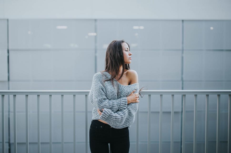Free Image of Young woman leaning on modern railing 