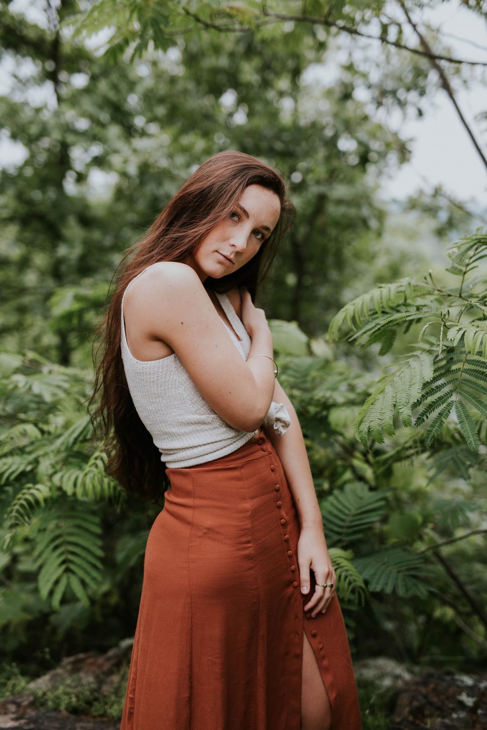 Free Image of Woman with thoughtful expression in the woods 