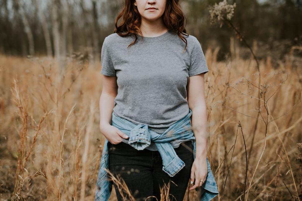 Free Image of Woman standing in dry grass field 