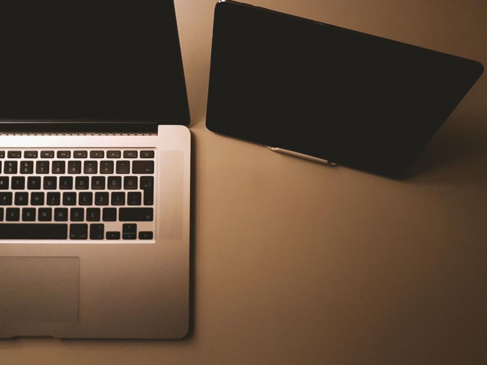 Free Image of Two laptops on a desk with soft lighting 