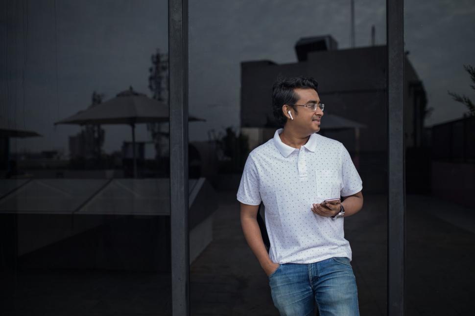 Free Image of Man leaning on glass with reflections 