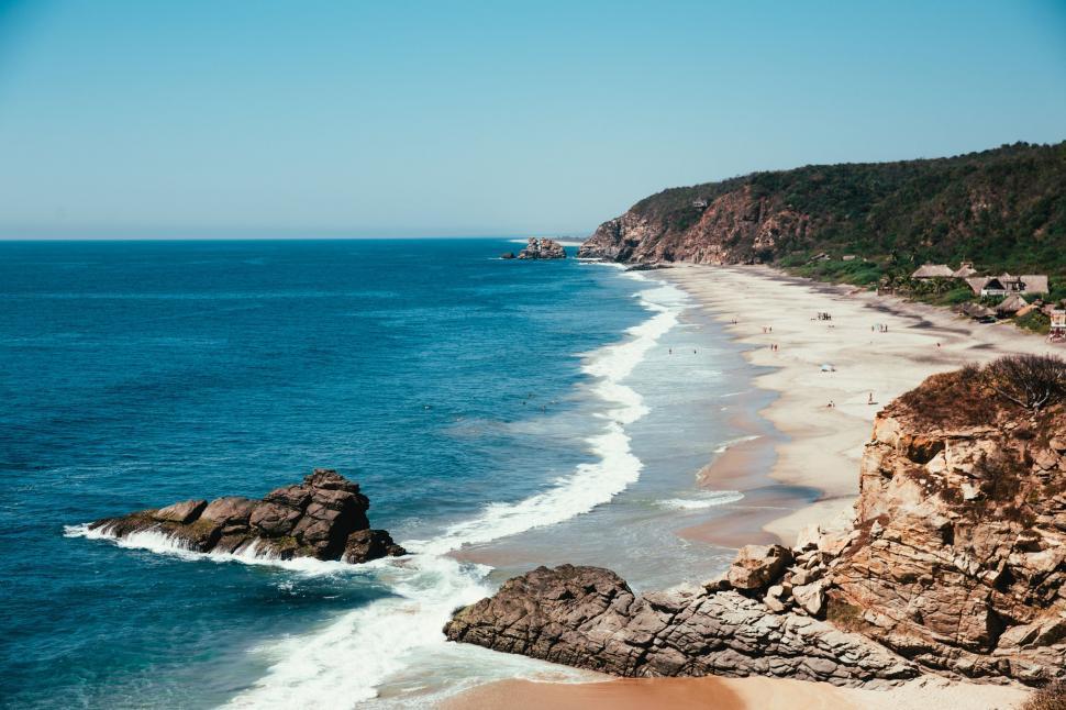 Free Image of Serene beach landscape with rocky outcrop 