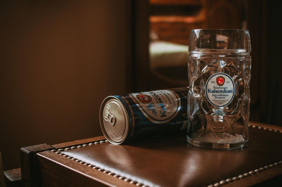 Free Image of Beer can and mug on leather surface 