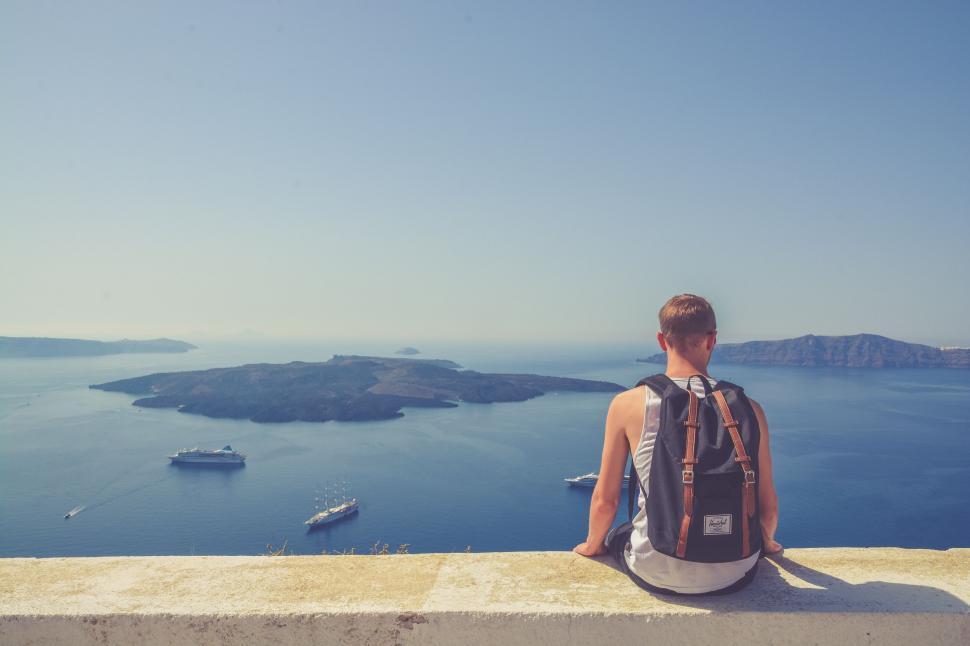 Free Image of Man overlooking the sea from a wall 