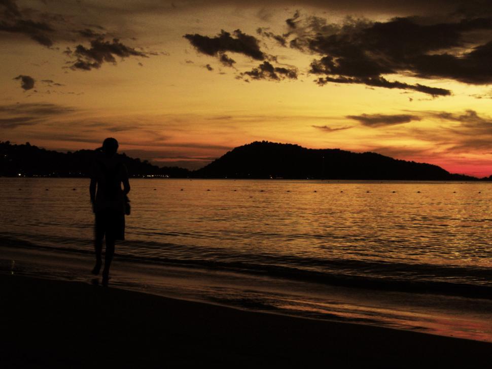 Free Image of Person Walking on Beach at Sunset 