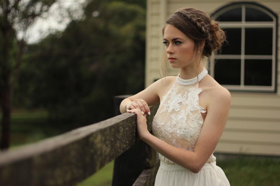 Free Image of Vintage-styled woman by a fence 
