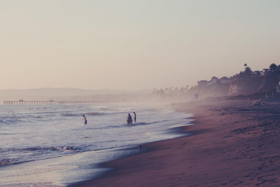 Free Image of Misty beach scenery with pier in the distance 