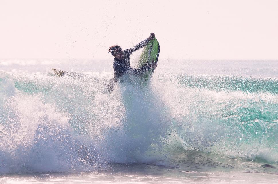 Free Image of Surfer tackled by a large ocean wave 