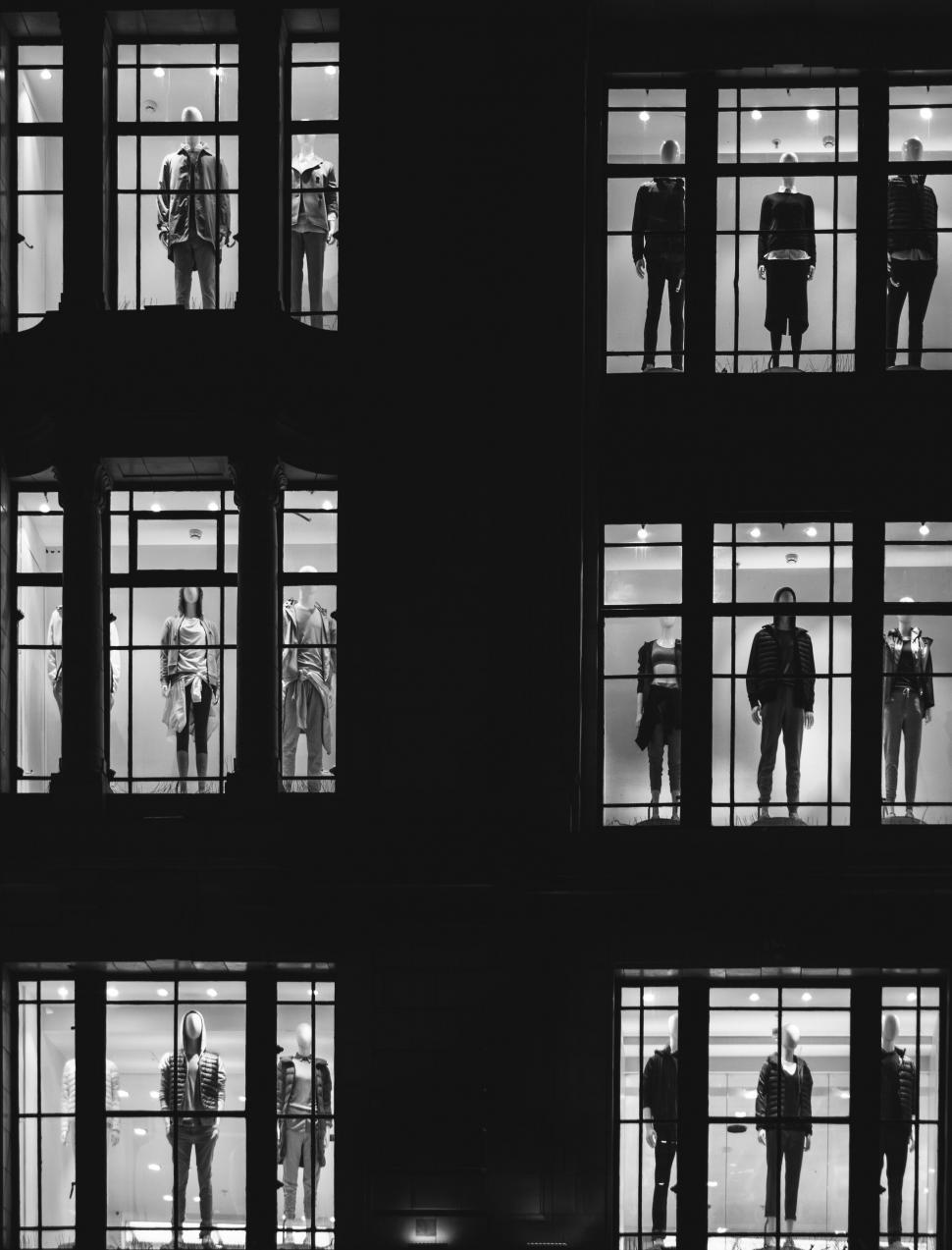 Free Image of Mannequins in lighted store windows at night 