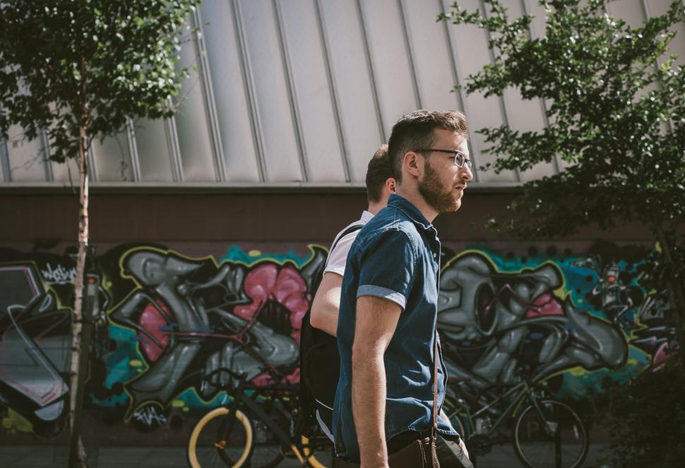 Free Image of Man walking in front of graffiti wall 