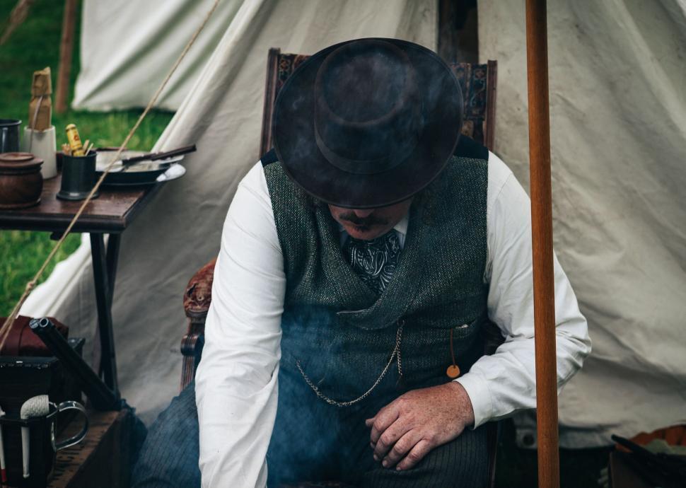 Free Image of Reenactment man sitting on a wooden chair 