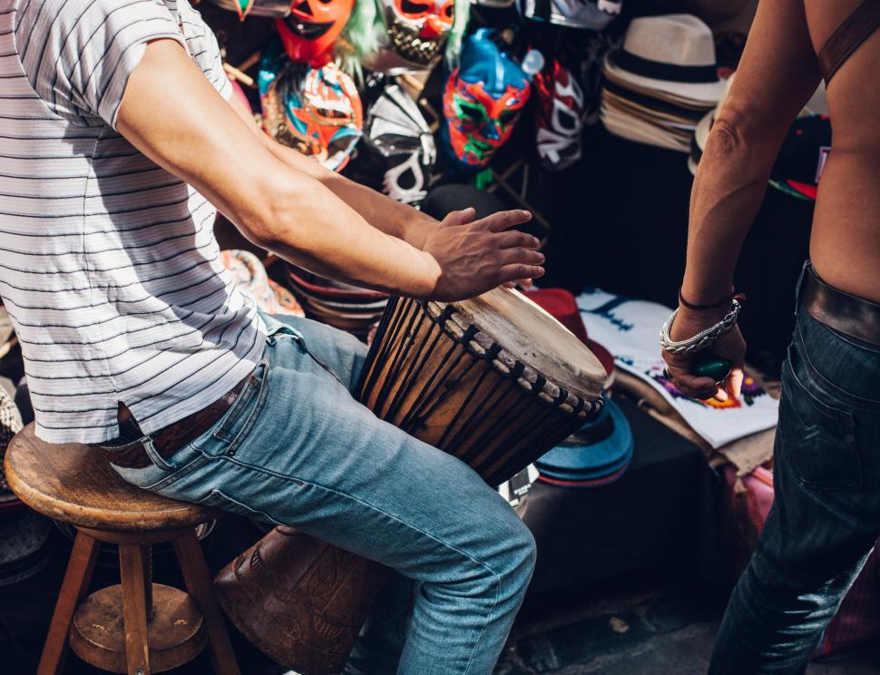 Free Image of Man playing a drum in a market 